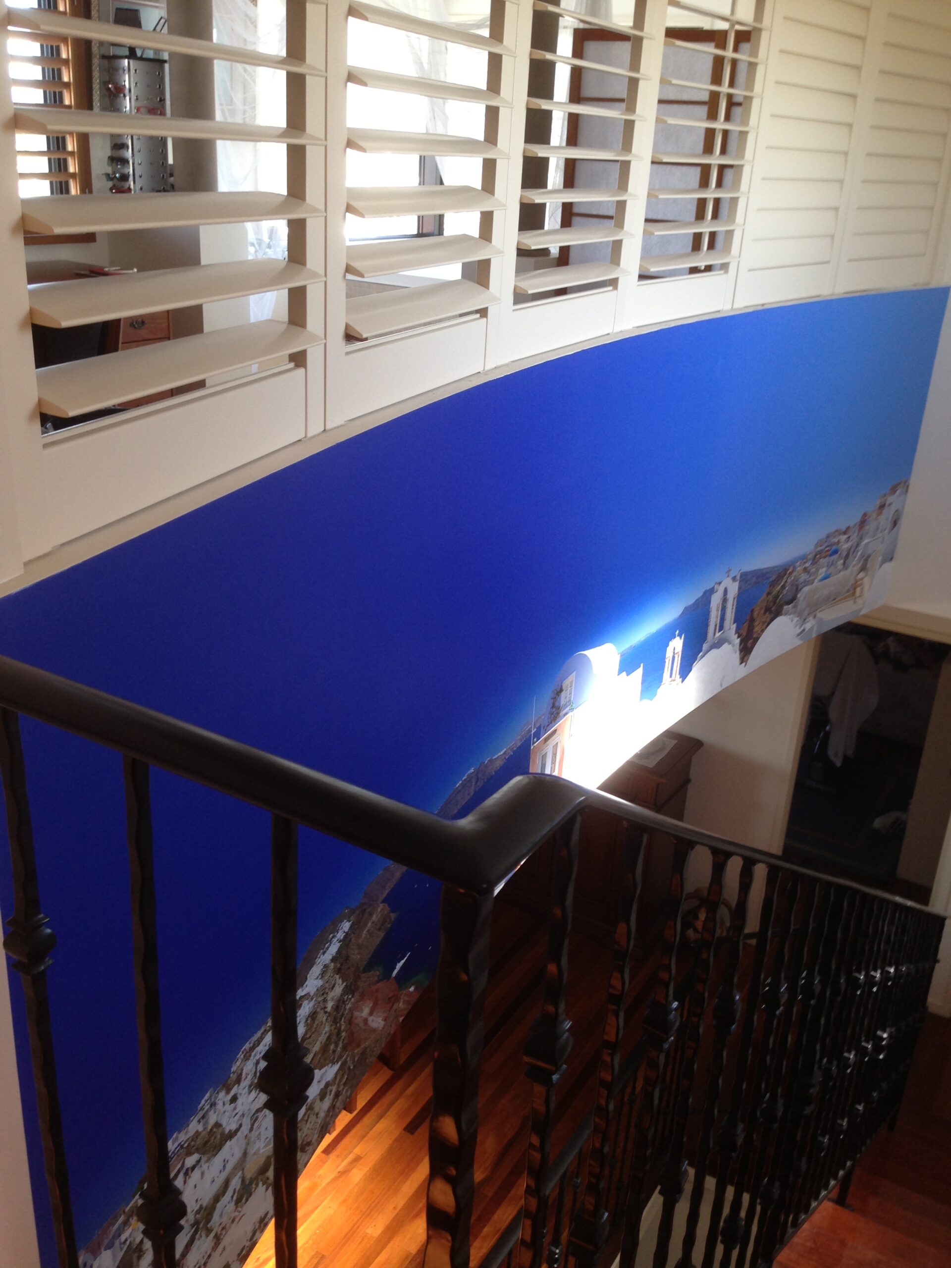 Santorini wallpaper mural hung above staircase
