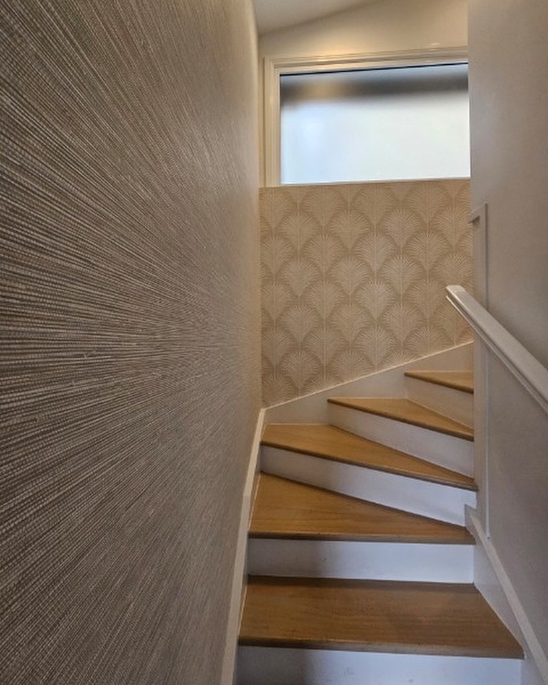 2 wallpaper patterns on a staircase in Grasslands plain and palm leaf designs