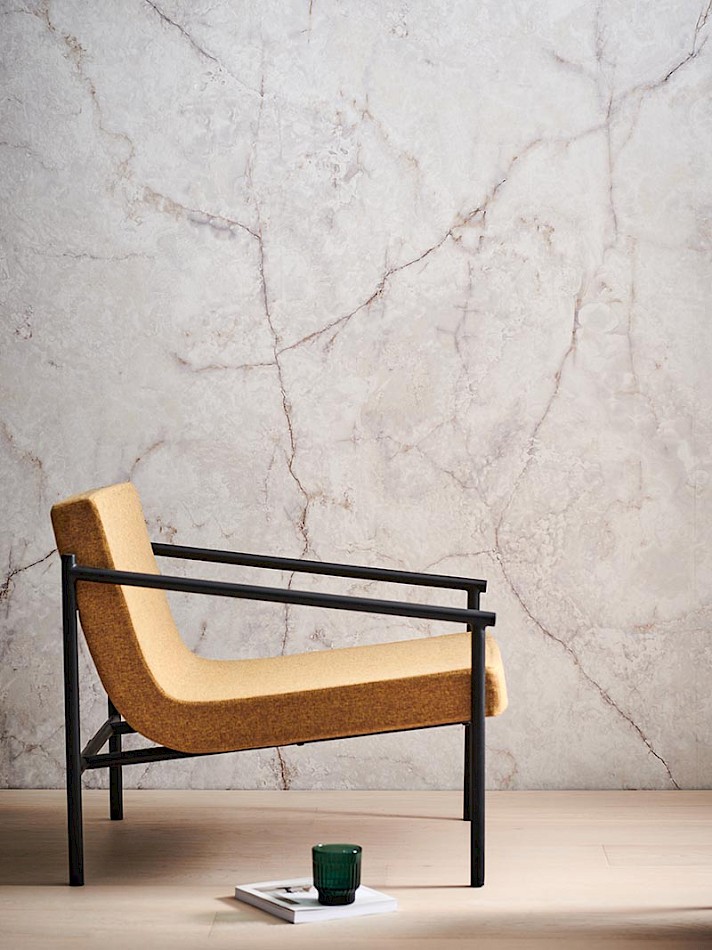 Designer chair in front of luxurious marbled wallpaper