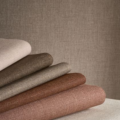 rolls of earthy coloured plain wallpaper